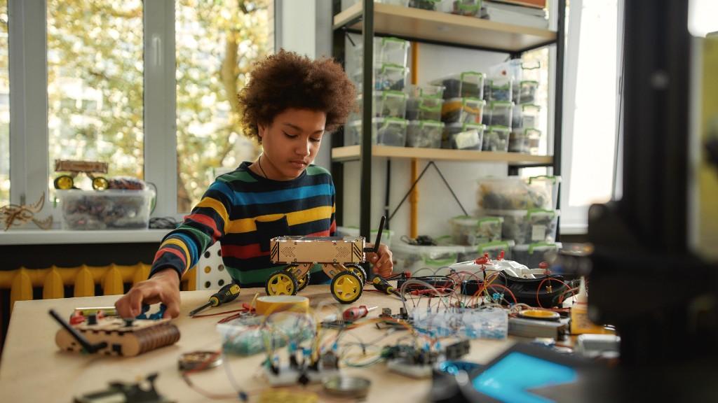Young inventor building and testing a prototype at a worktable